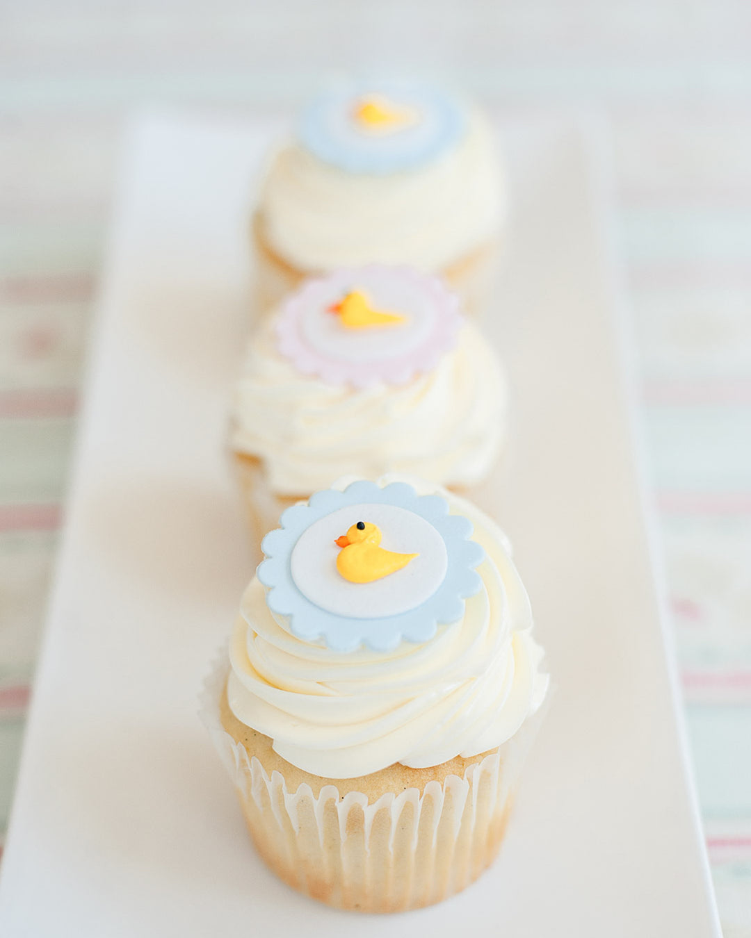 Baby Duckie cupcakes with yellow sugar ducks for a baby shower, by Bobbette & Belle