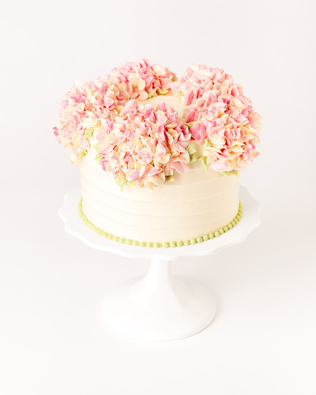 Cake covered in piped buttercream hydrangea flowers, by Bobbette & Belle Toronto