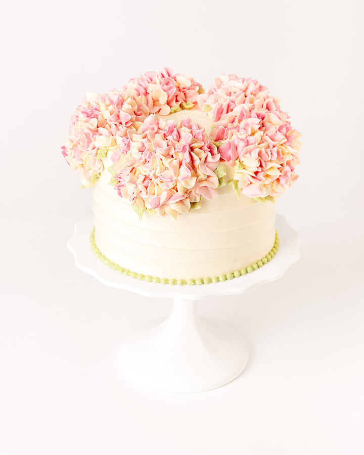 Cake covered in piped buttercream hydrangea flowers, by Bobbette & Belle Toronto