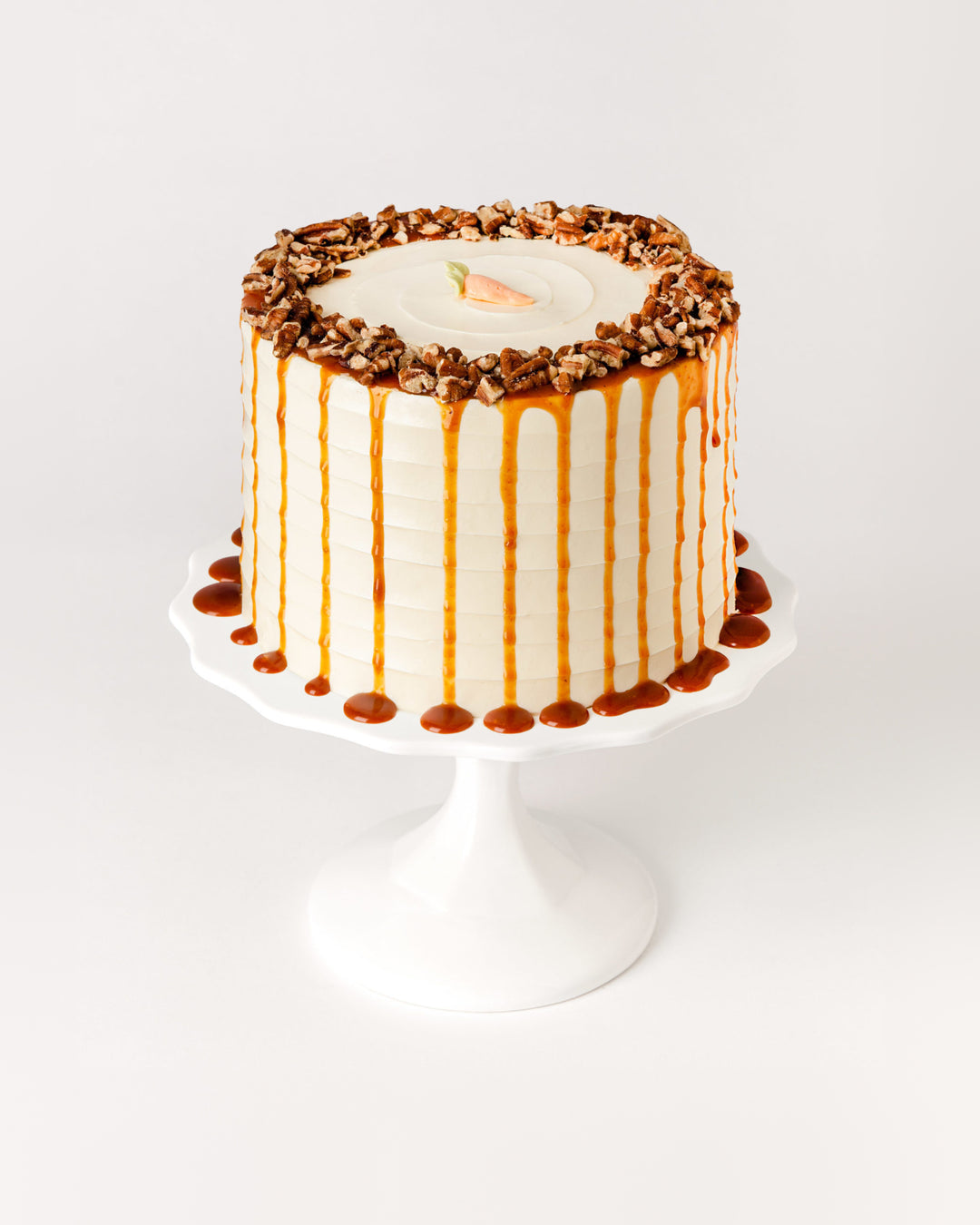Carrot cake with cream cheese buttercream, toasted pecans and caramel drizzle