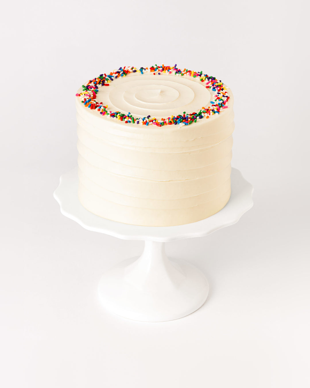Classic vanilla sprinkles cake with buttercream swirl and rainbow sprinkles