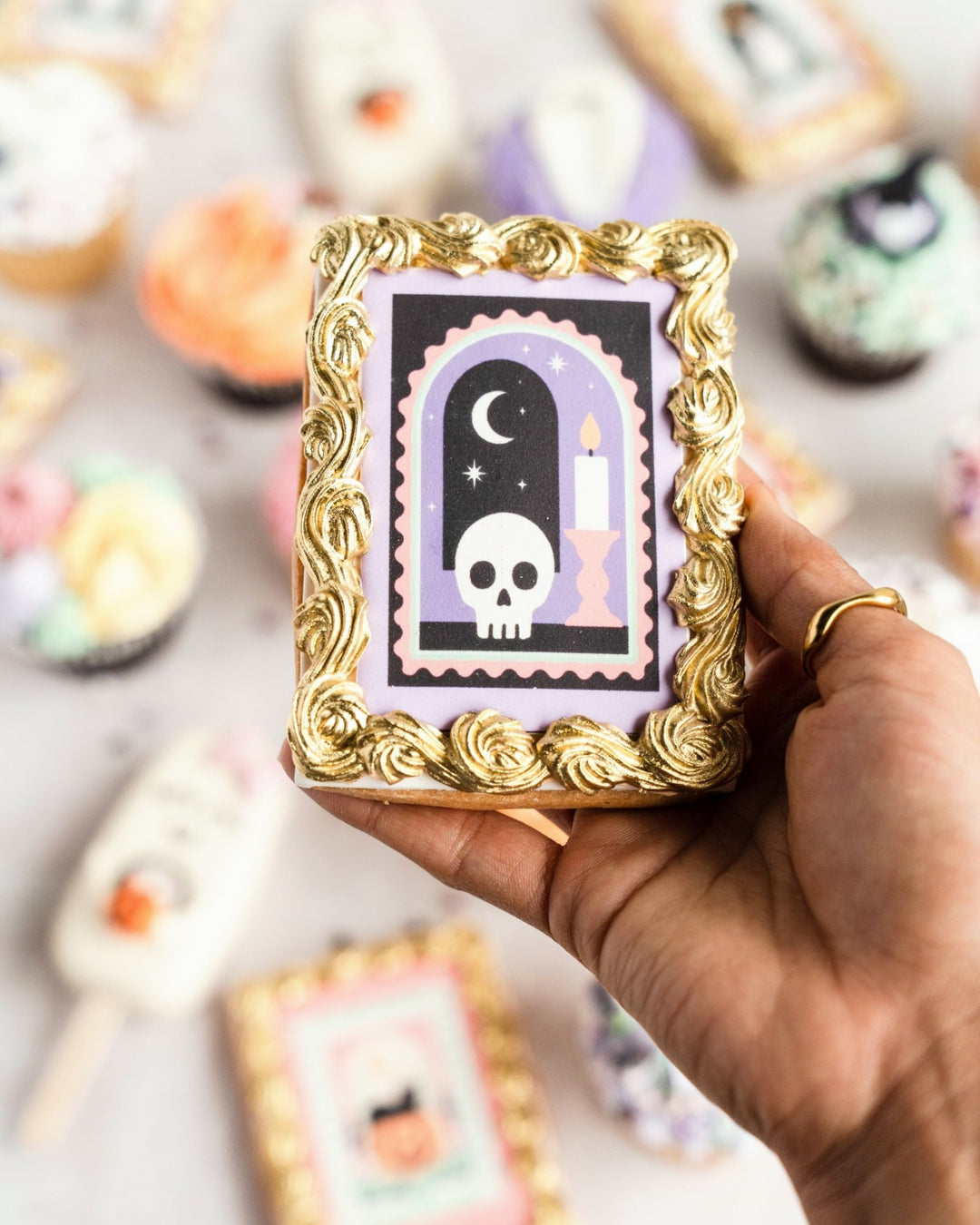 Skull and candle Halloween framed cookie held in hand