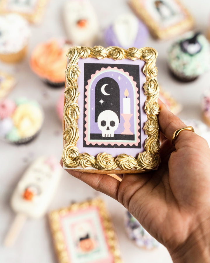 Skull and candle Halloween framed cookie held in hand
