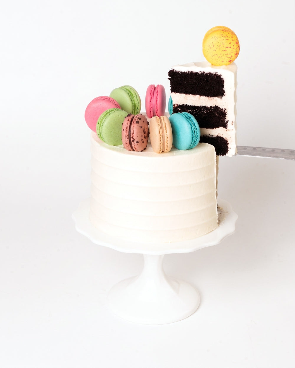 Slice of Macaron Lovers Cake showing chocolate cake layers and vanilla buttercream