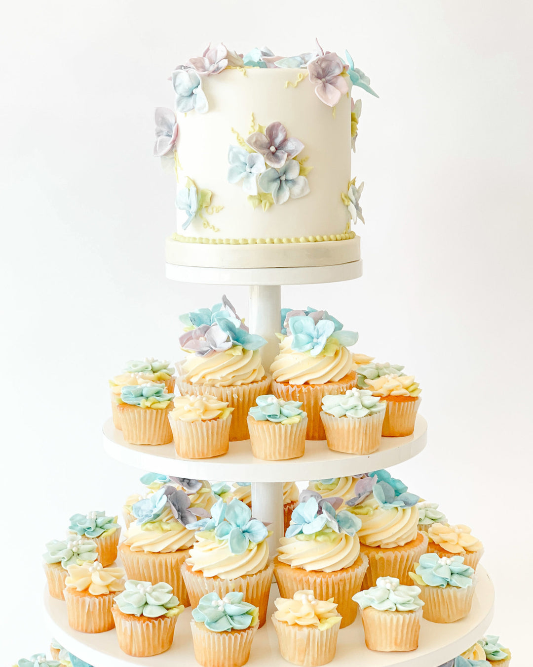 Cupcake tower topped with handmade sugar hydrangeas for a wedding or event