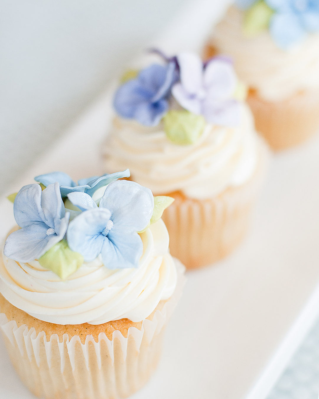 Cupcakes topped with handmade sugar hydrangea flowers, by Bobbette & Belle Toronto