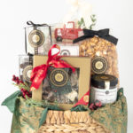 A beautifully arranged holiday gift basket featuring gourmet treats, including caramel popcorn, chocolates, cookies, and preserves, wrapped with festive ribbons and accents.