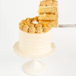 Close-up of caramel banana cream cake topped with dulce de leche buttercream and banana chips