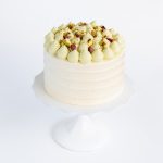 pistachio Rhubarb cake placed on a white china pedestal