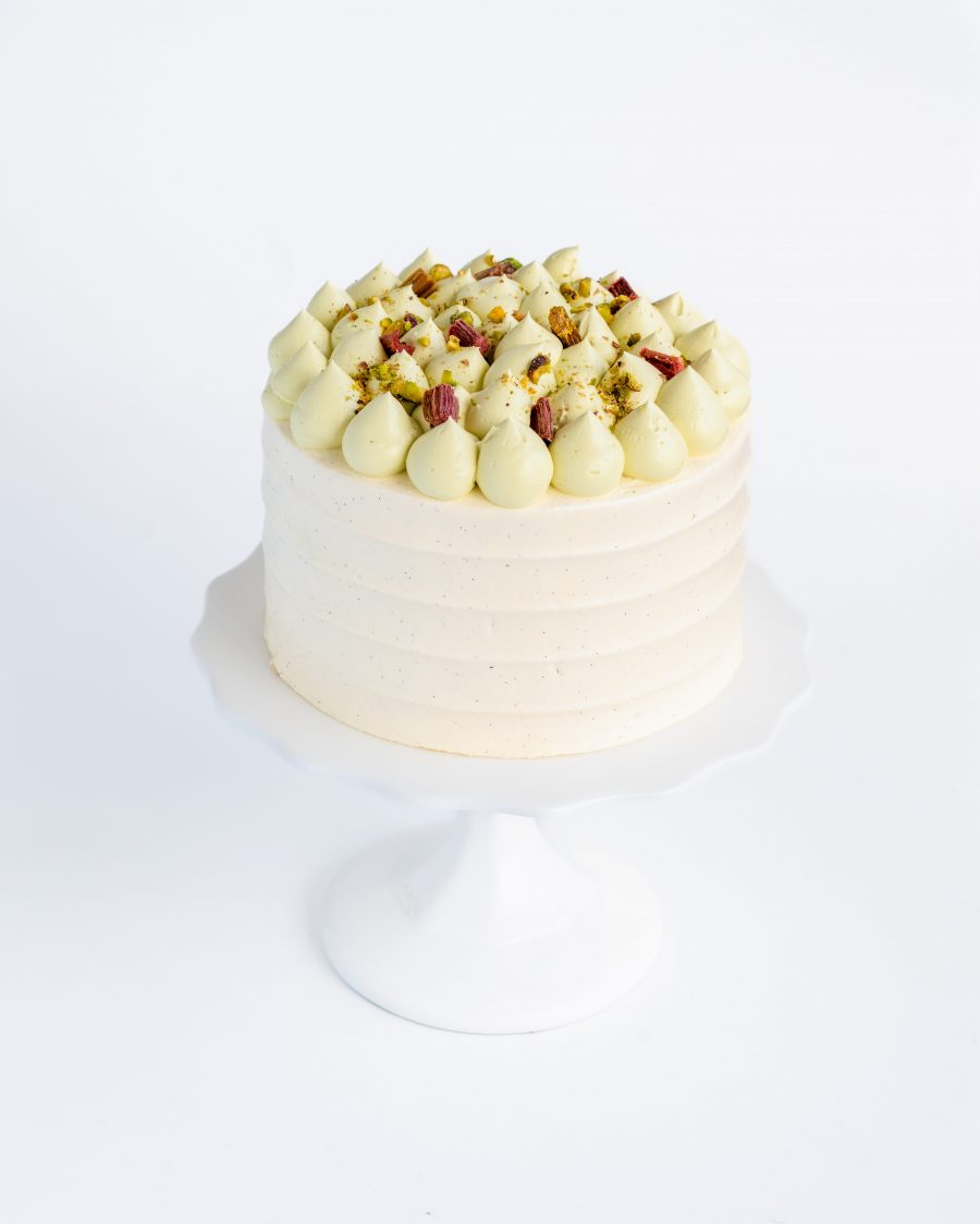 pistachio Rhubarb cake placed on a white china pedestal
