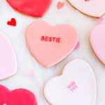 Heart-shaped sugar cookies with fondant icing and Valentine’s messages like XOXO, YAAS, and BE MINE.