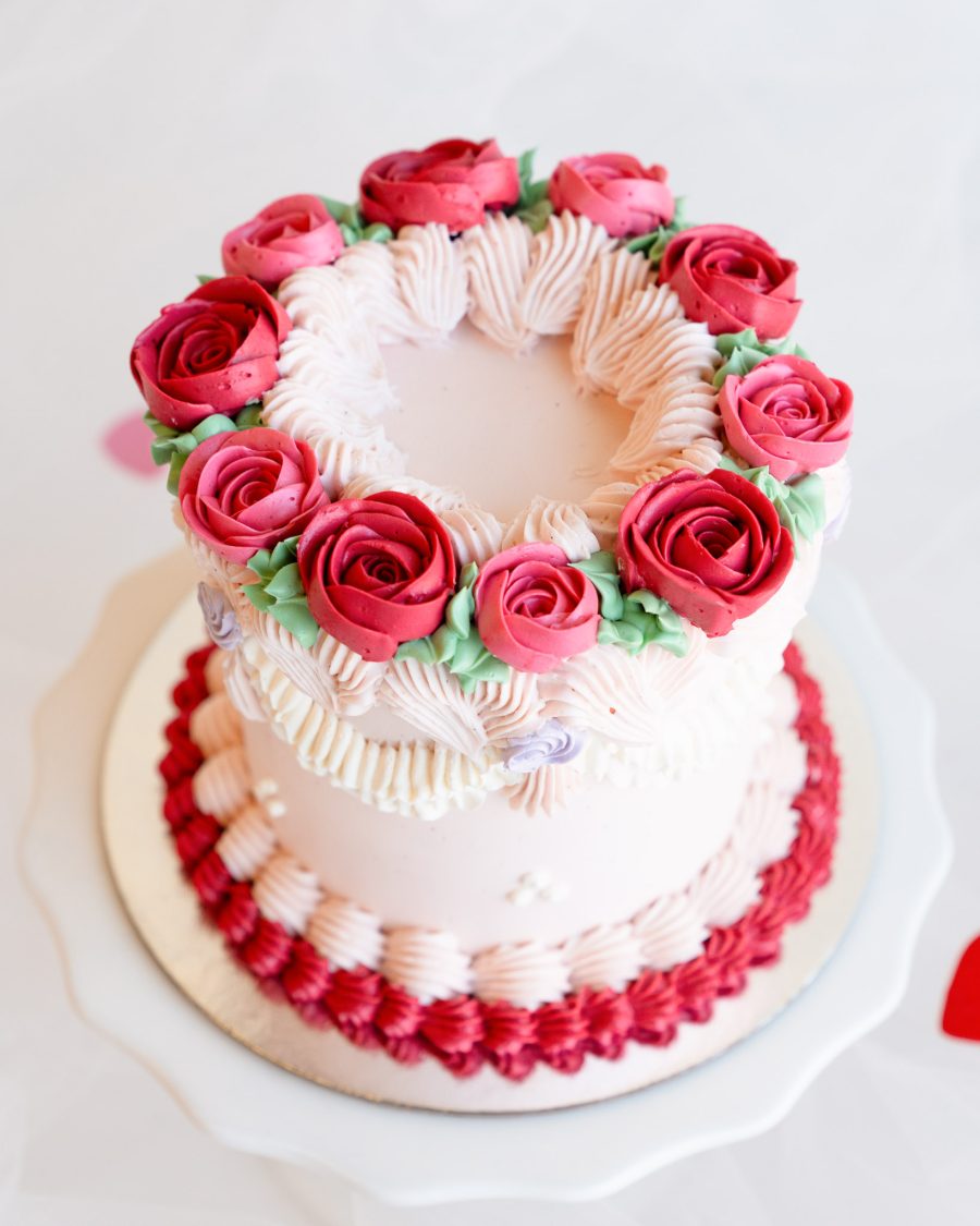 Close-up view of red and pink buttercream roses on a mini Valentine’s cake.