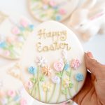 Easter egg sugar cookie with pastel floral icing and Happy Easter lettering, packaged for gifting