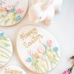 hand decorated Easter egg sugar cookie with pastel flowers and gold lettering, gift packaged with ribbon