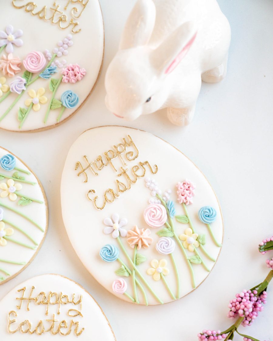 hand decorated Easter egg sugar cookie with pastel flowers and gold lettering, gift packaged with ribbon