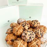 mixed boxes of hot cross scones and blueberry scones on platter with bakery boxes in background