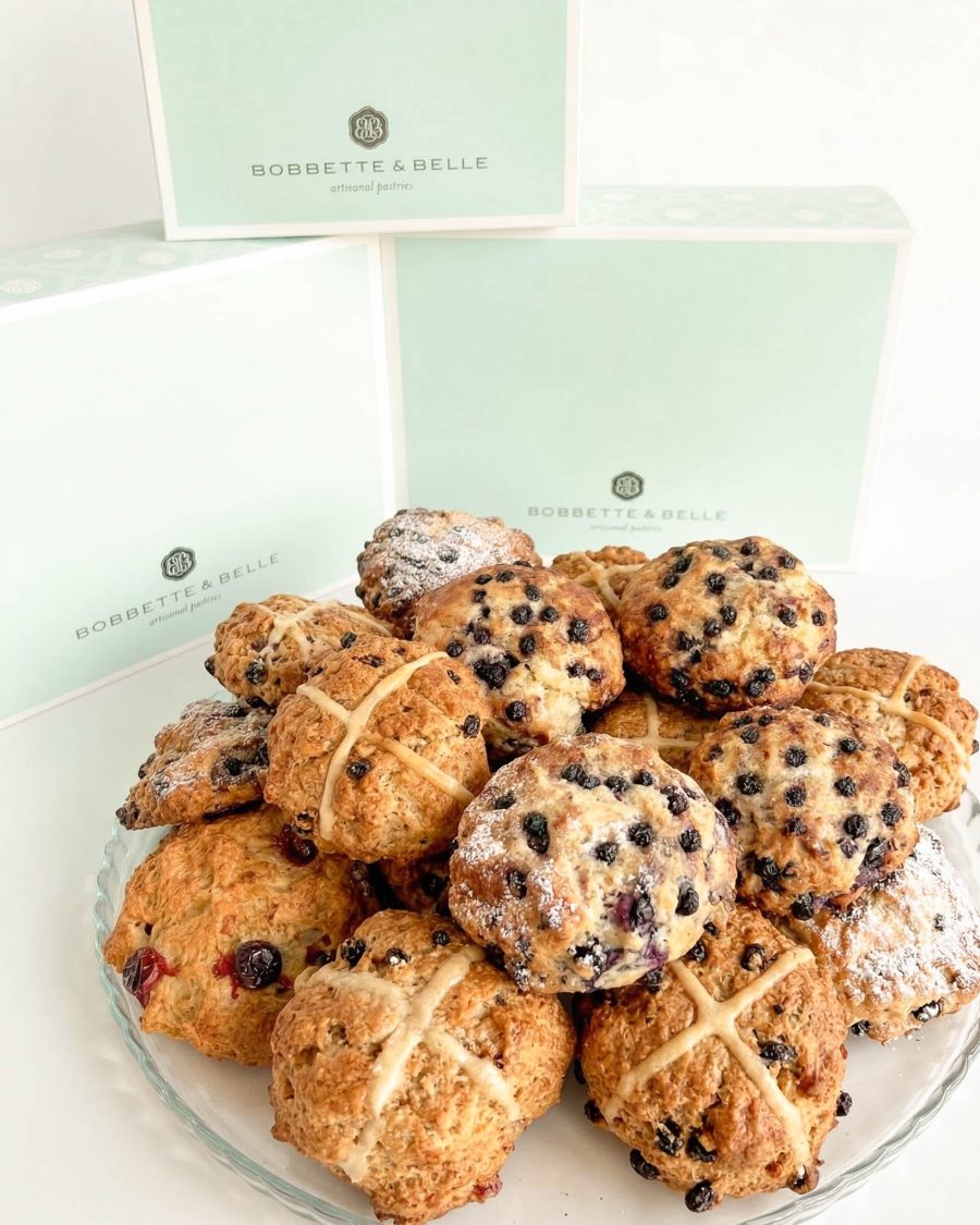 mixed boxes of hot cross scones and blueberry scones on platter with bakery boxes in background